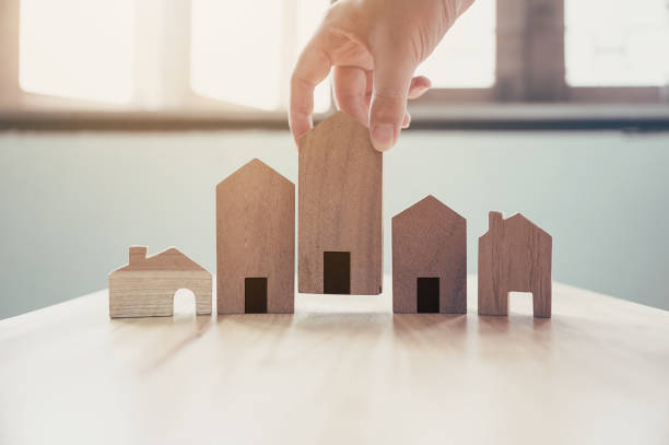 Hand choosing wooden house model, Mortgage and real estate property investment